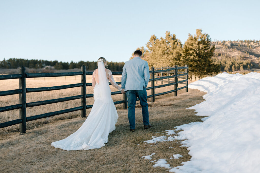 bride and groom holding hands and walking at Spruce Mountain Ranch