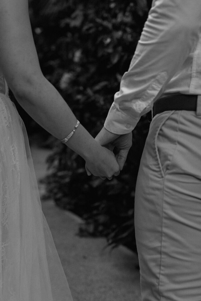 bride and groom detail photos holding hands in the jungle