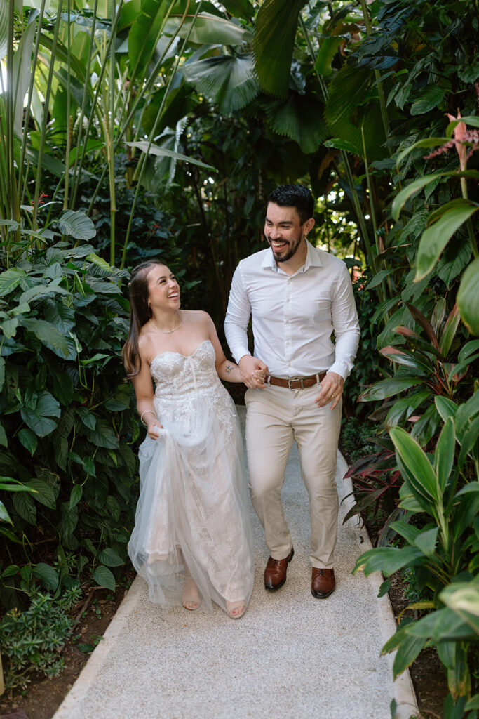 jungle destination elopement bride and groom holding hands and laughing