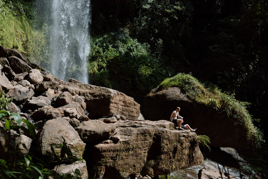 tropical couple photos in front of waterfall