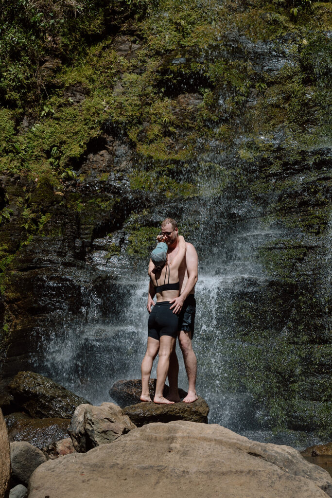 couple kissing underneath waterfall