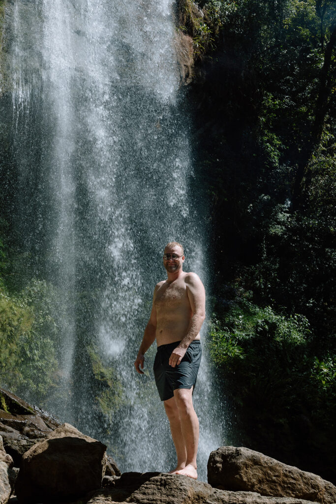 groom standing in front of costa rica waterfall in uvita