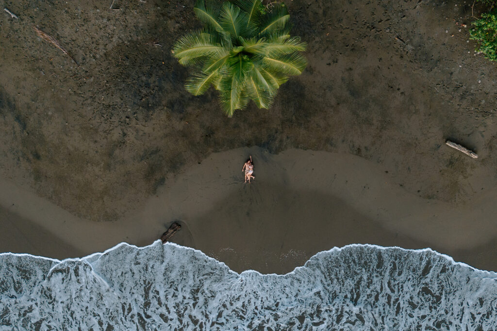 drone shot of a couple laying on the beach