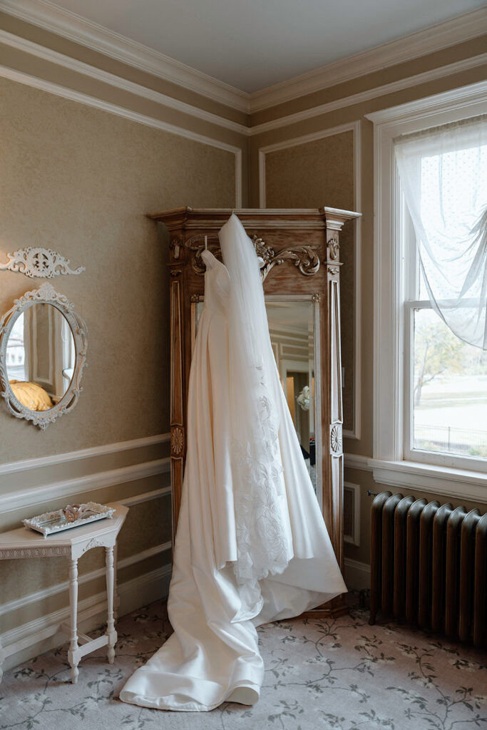 The Stephanie's Bridal Boutique dress hangs from the armoire in the Historic Longview Mansion bridal suite.
