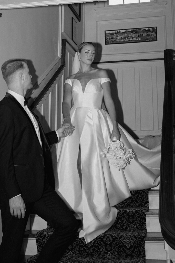 Black and white editorial style wedding picture taken on the grand staircase inside the Historic Longview Mansion.