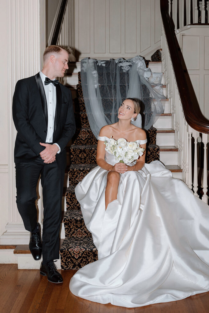 Taylor and Reece admiring each other in their wedding outfits for wedding styled shoot at the luxury Kansas City wedding venue: the Historic Longview Mansion.