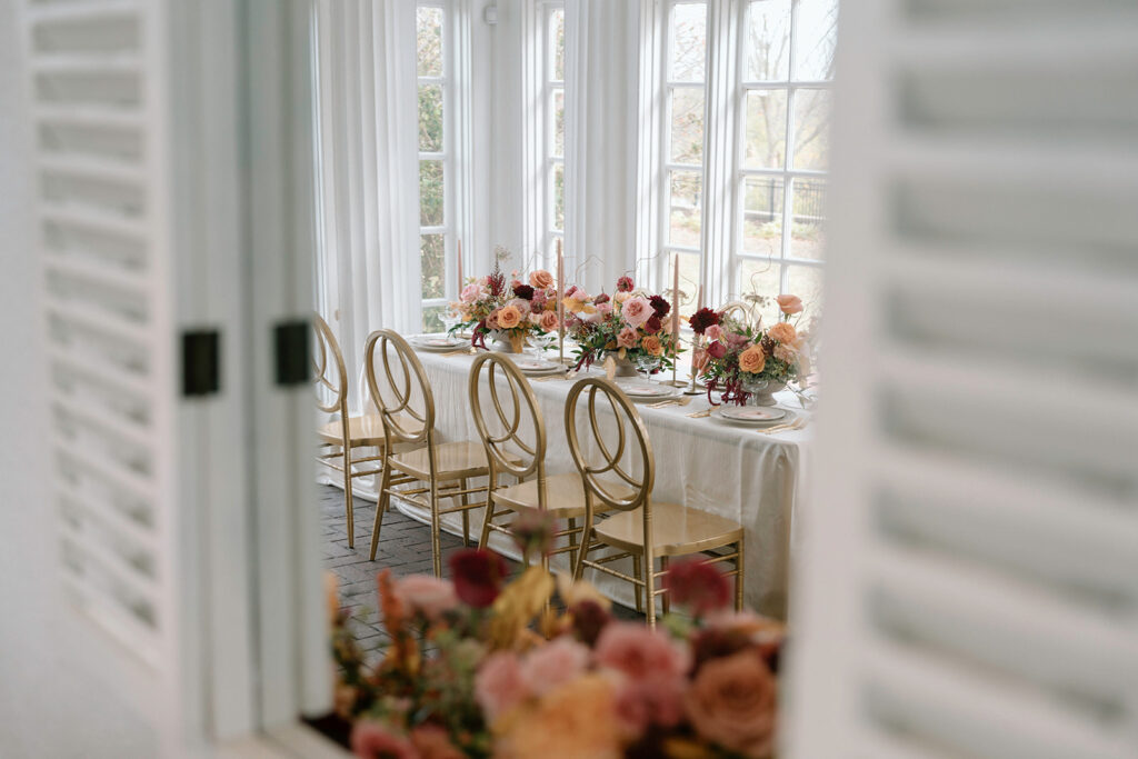 A unique wedding photo of the reflection of a luxury tablescape designed by The Perfect Touch KC with linens and rentals from Quest Events and Floriography florals for a styled Longview Mansion wedding.