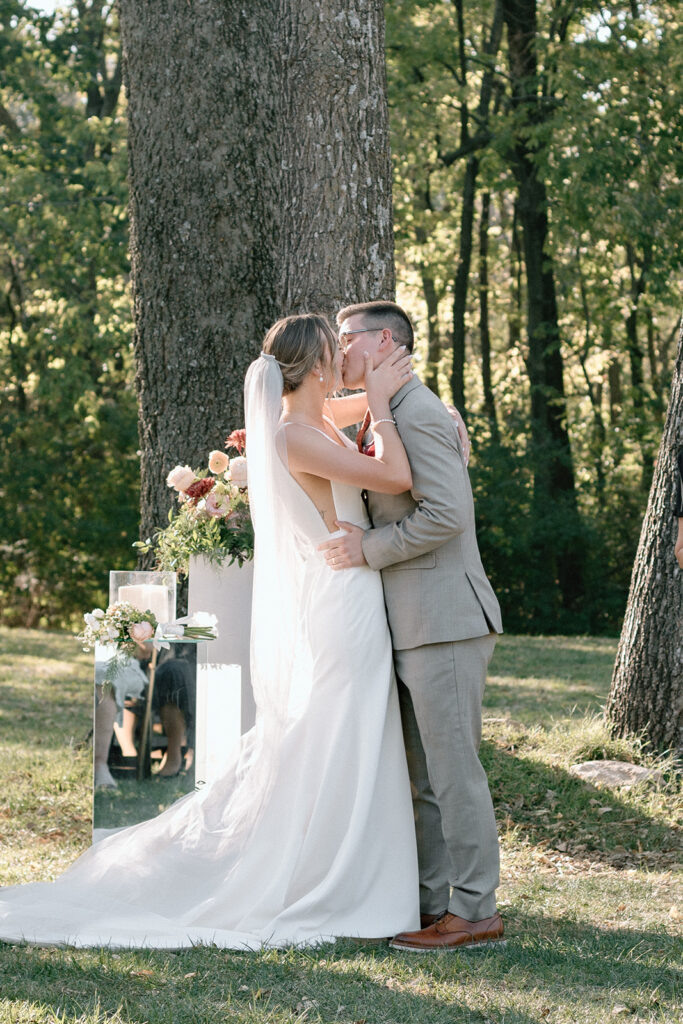 bride and groom first kiss for fall wedding at Gather at Red Cedar Gardens
