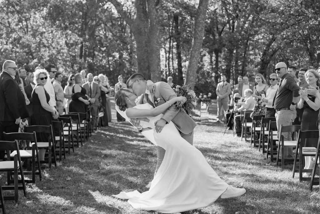 bride and groom dip at the end of the aisle for fall wedding at Gather at Red Cedar Gardens