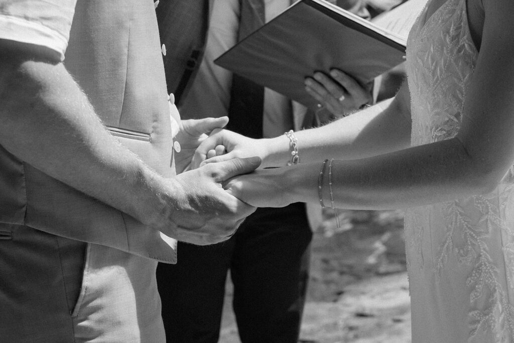 Bride and groom holding hands during a tropical waterfall elopement.