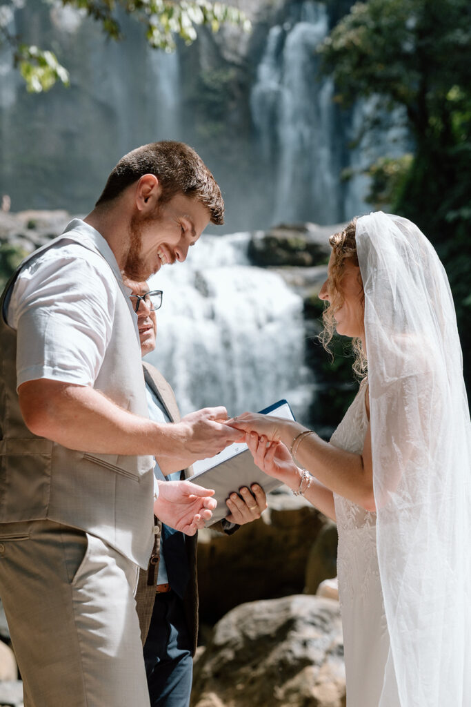 Exchanging the rings during a tropical waterfall elopement.