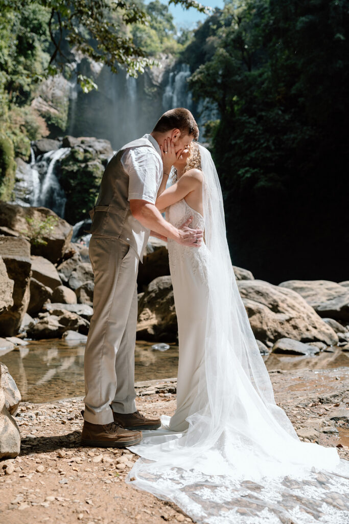 Bride and groom's first kiss on elopement day at Nauyaca Waterfall Nature Park.