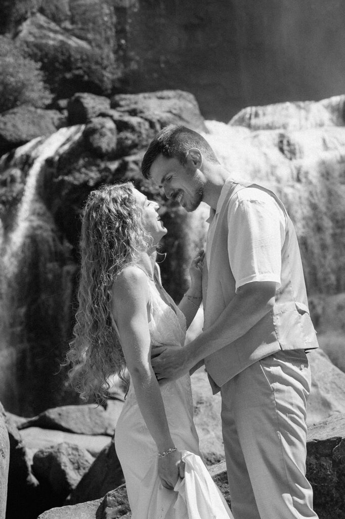 Staci and Cole exploring the waterfall for adventurous wedding pictures.